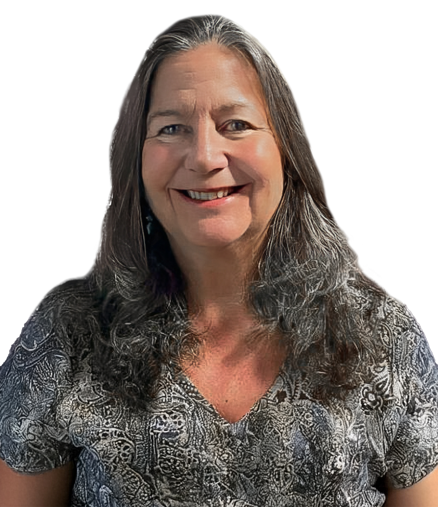 A woman with long wavy gray hair wearing a patterned blouse, smiling against a white background.