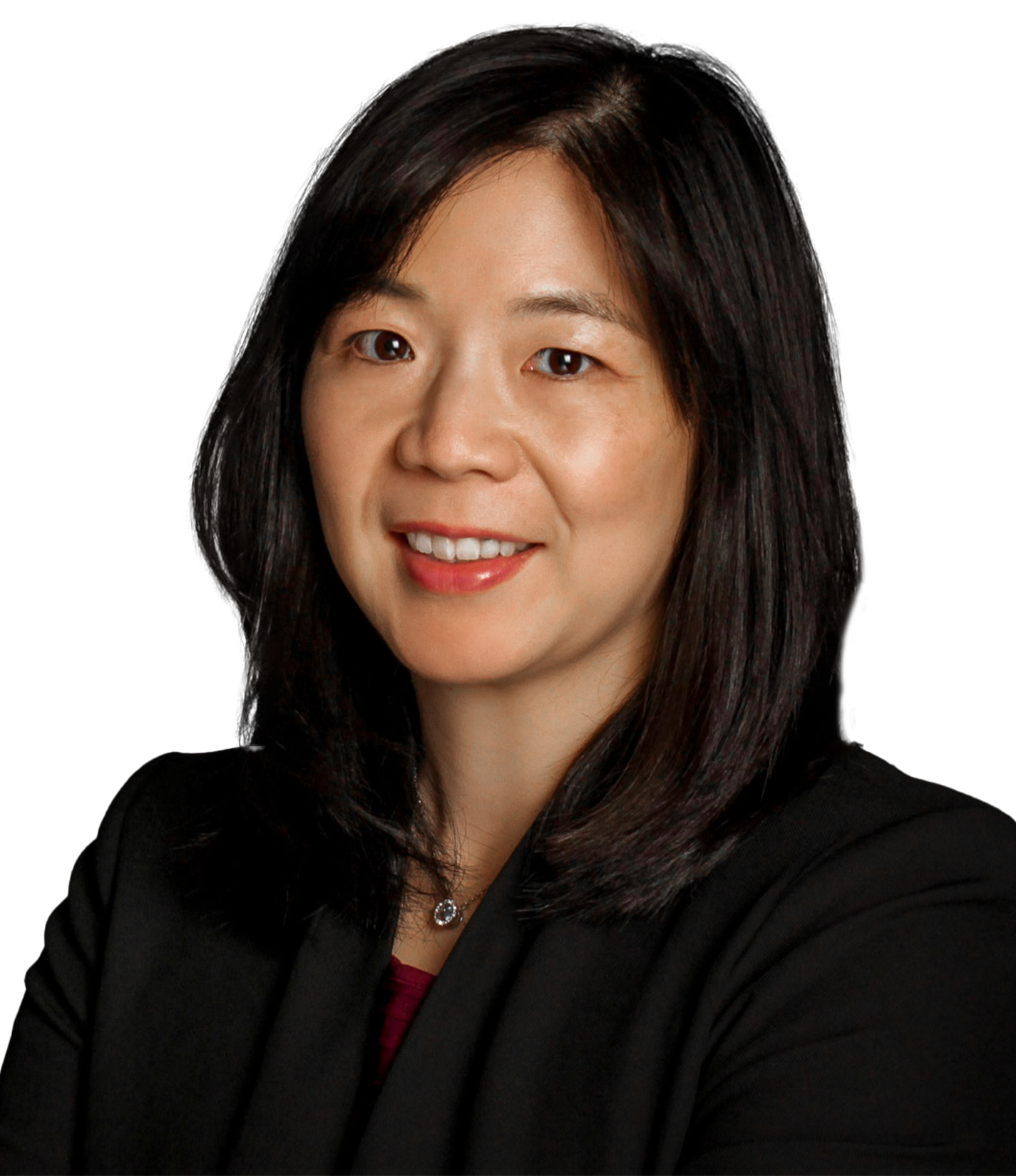 A woman with straight dark hair wearing a black blazer and necklace, smiling against a white background.