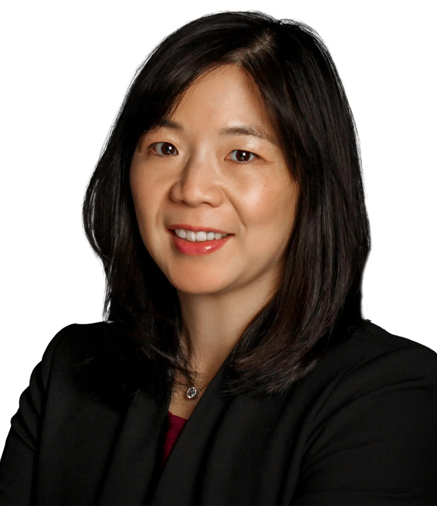 A woman with straight dark hair wearing a black blazer and necklace, smiling against a white background.