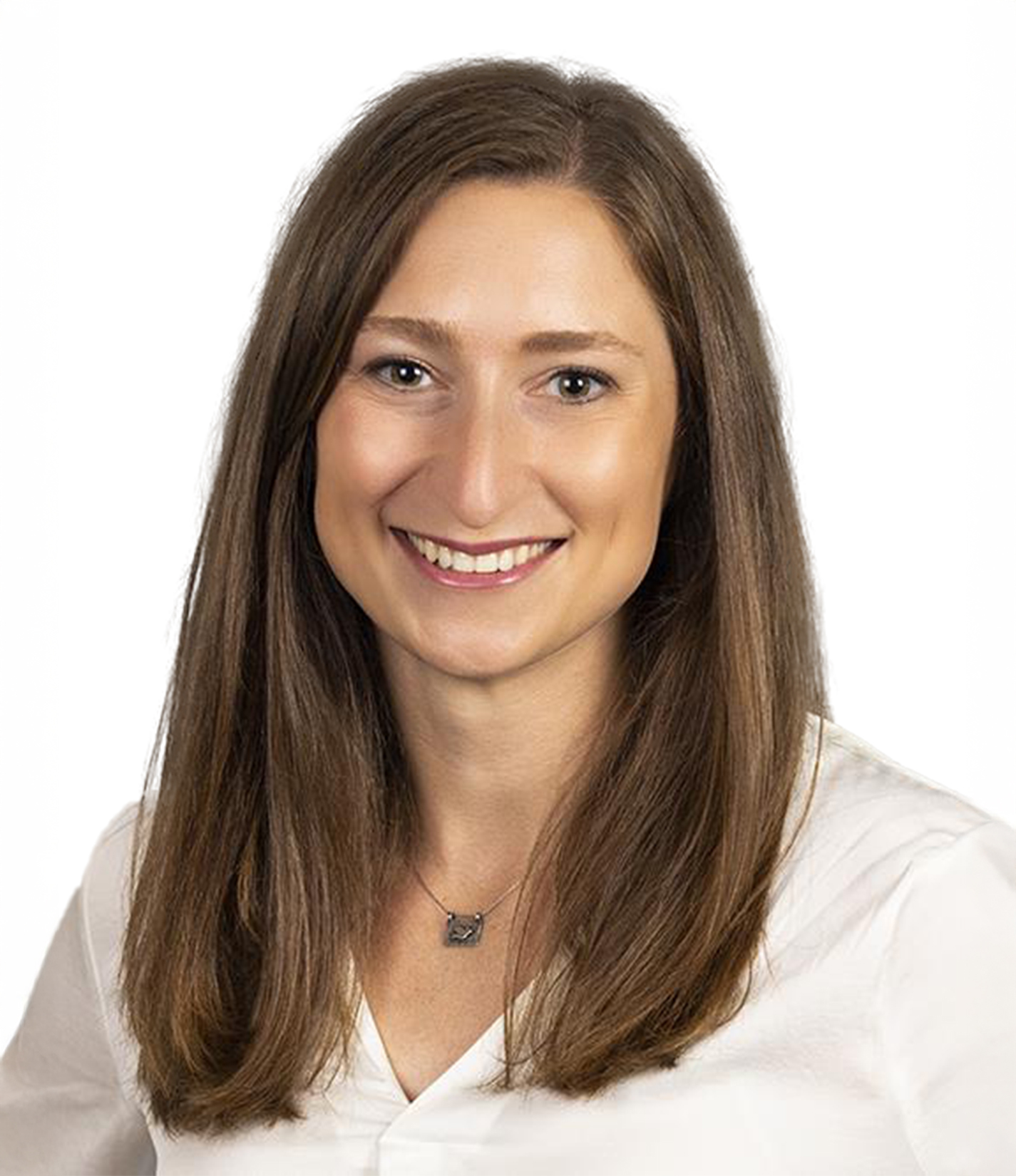 A woman with long straight brown hair wearing a white blouse and necklace, smiling against a white background.
