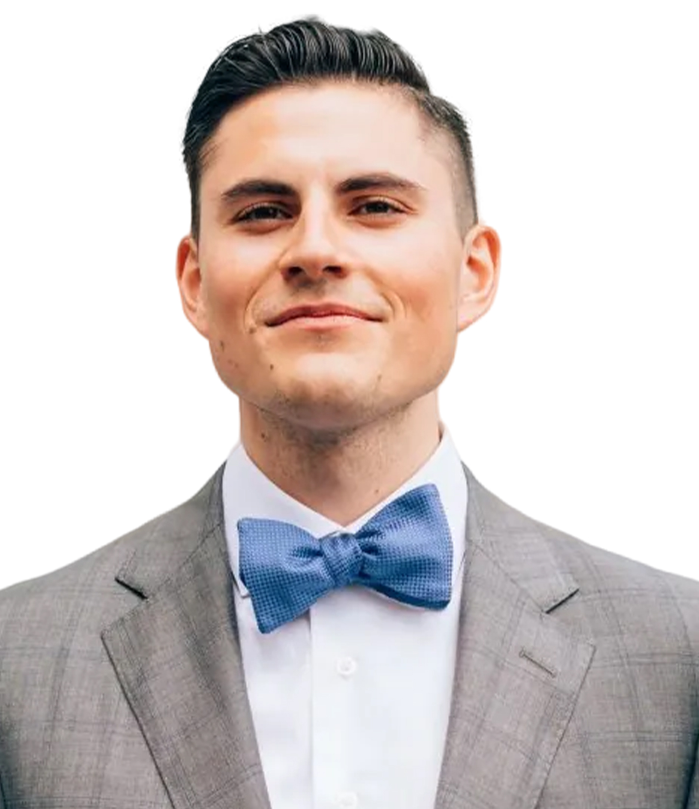 A man with short dark hair wearing a light gray suit, white shirt, and blue bow tie, smiling slightly against a white background.