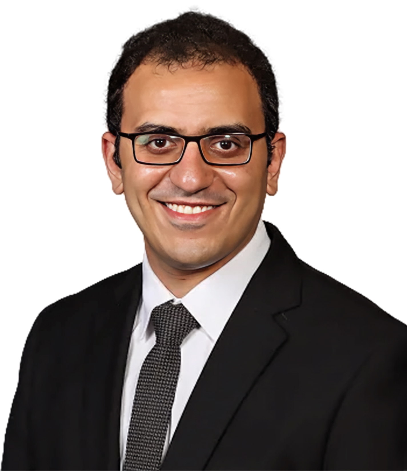A man with short dark hair and glasses, wearing a black suit, white shirt, and patterned tie, smiling against a white background.