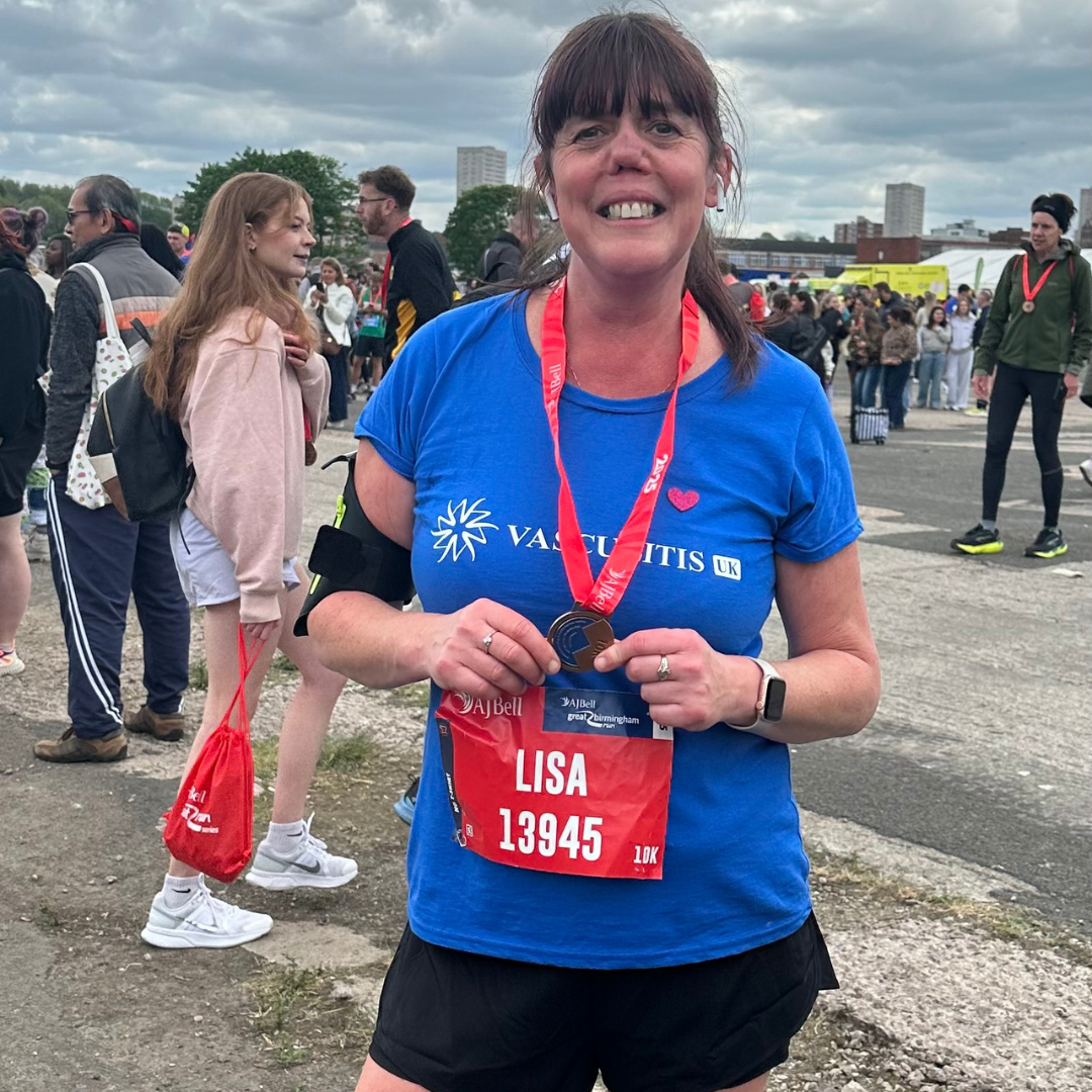 Lisa picture outside smiling with medal after finishing 10k race.