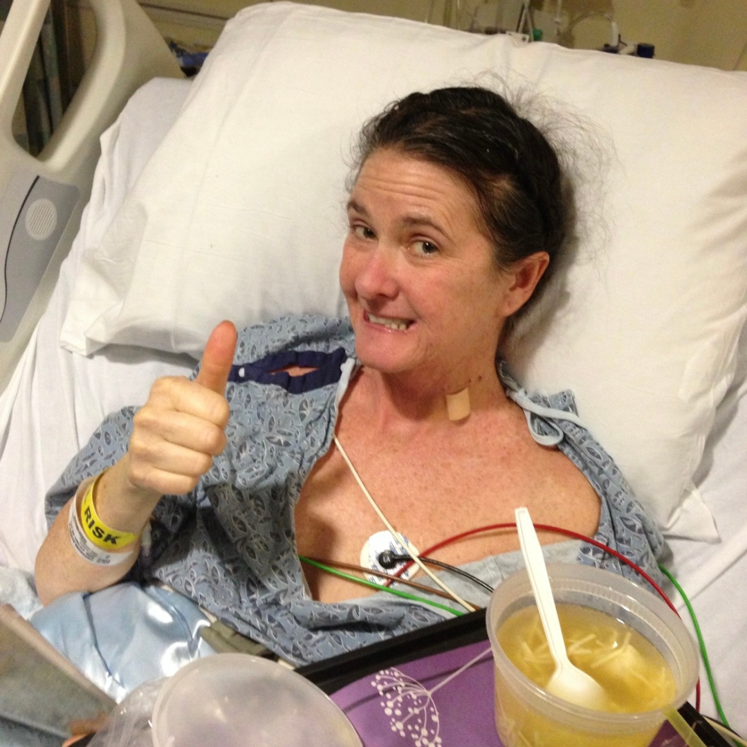 Regina pictured smiling with a thumbs up during a hospital visit
