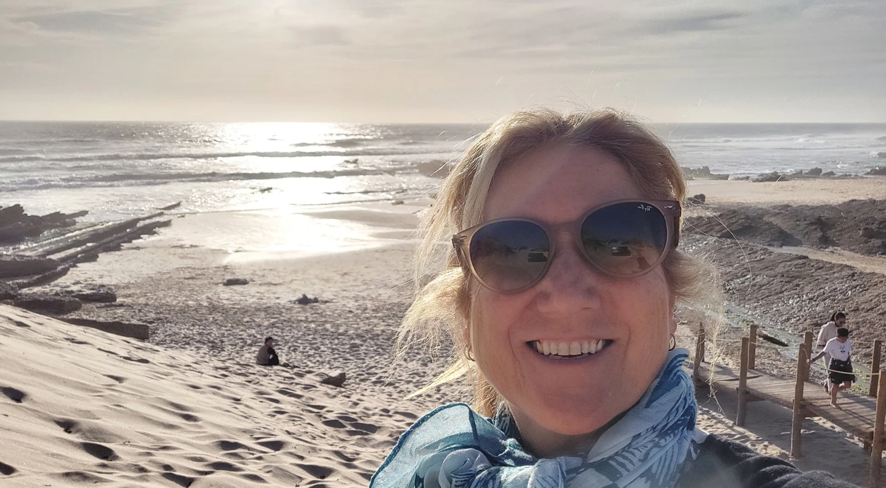 Alejandra outside smiling at the beach.