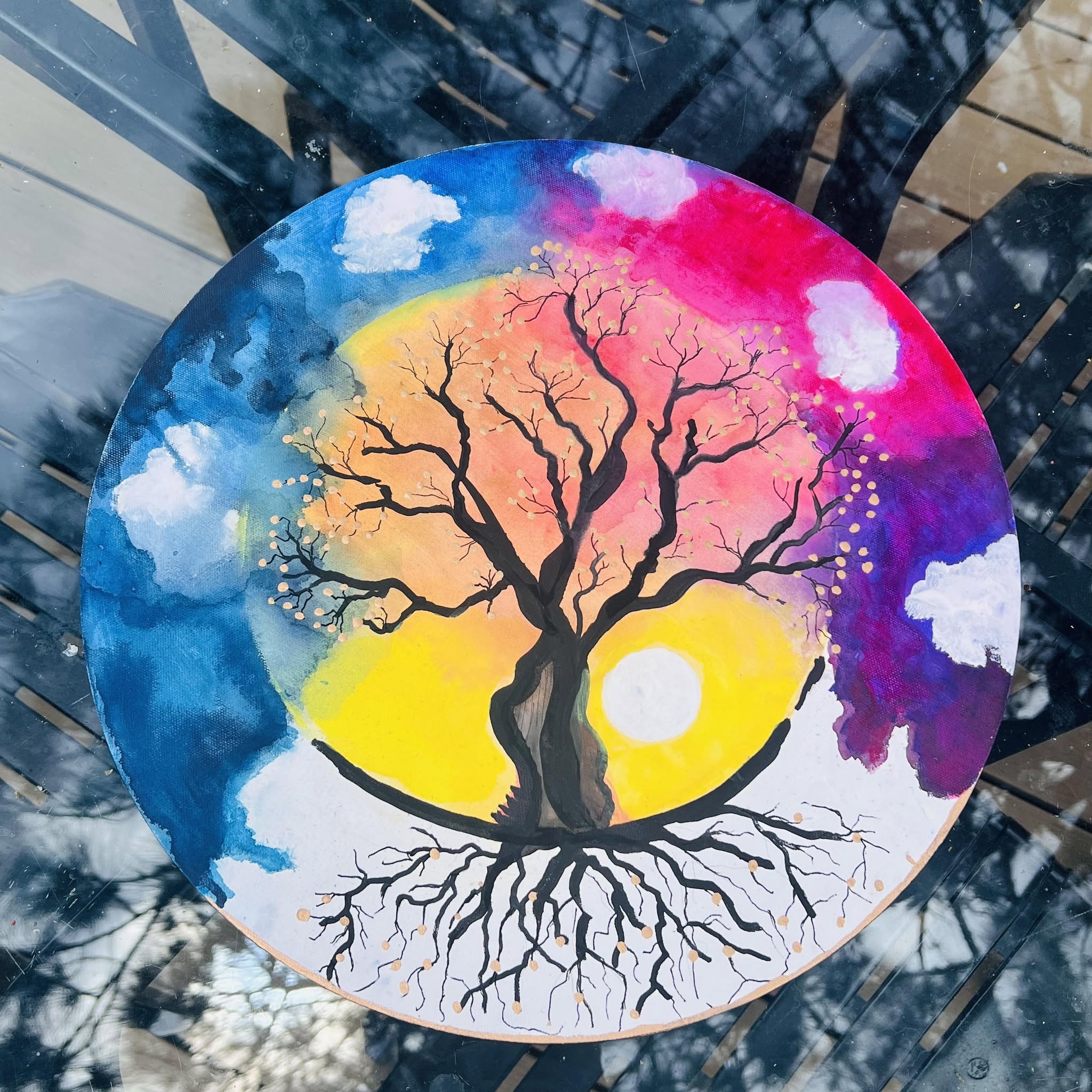 Painting of a tree with roots and a colorful sunset