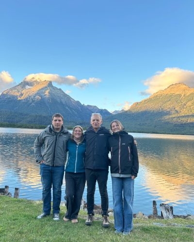 Alejandra pictured outside in front of lake and mountain with family