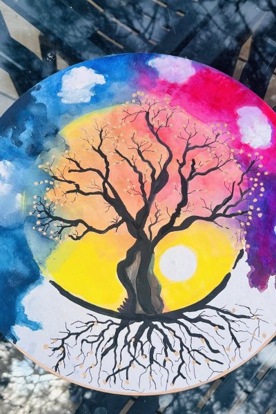 Painting of a tree with roots and a colorful sunset